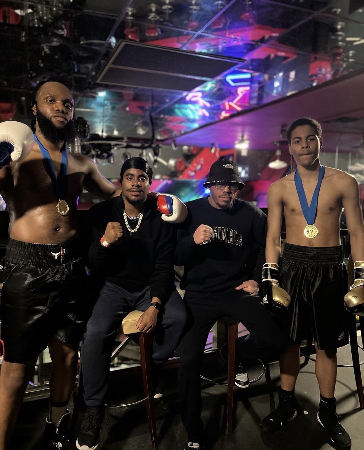 Two medal-winning fighters with their coaches on fight night